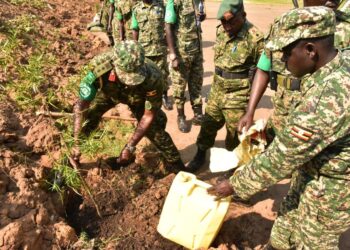 Col-Hyeroba-planting-a-tree-outside-the-his-office-compound-as-other-officers-look-on