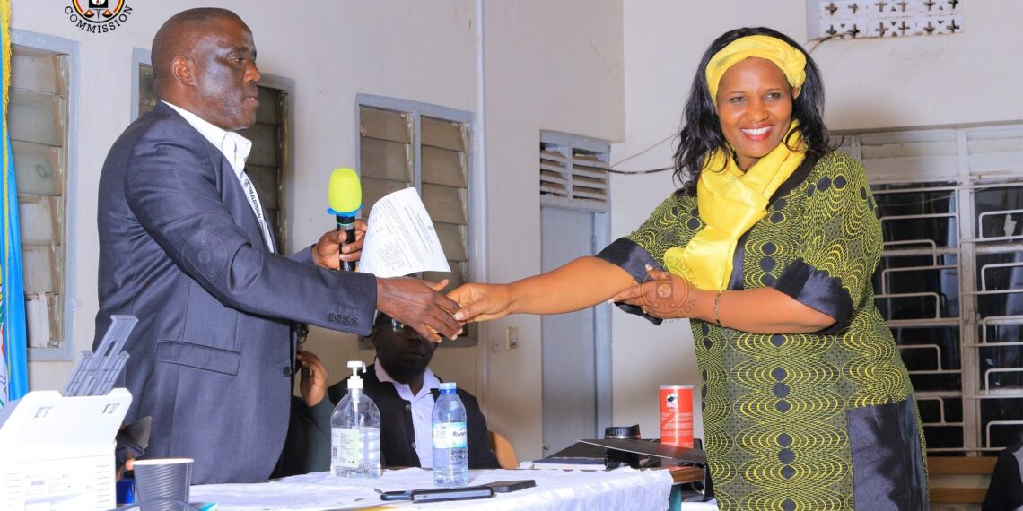 Akifeza Grace Ngabirano receives a copy of the results from Kisoro returning officer, Daniel Nayebae, after being declared the winner. [Credit EC]