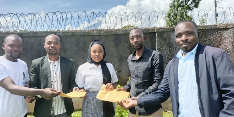 Kyanda Steven, a teacher at Kisoro Pearl High School receives his prize alongside the student who nominated him on Monday